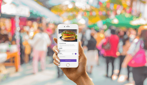 Hand holding smartphone showing mobile food ordering application