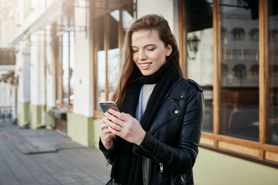 Woman Outside of Store Looking at Mobile