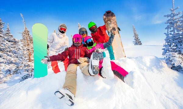 Snowboarders posing for a silly photo together in the snow